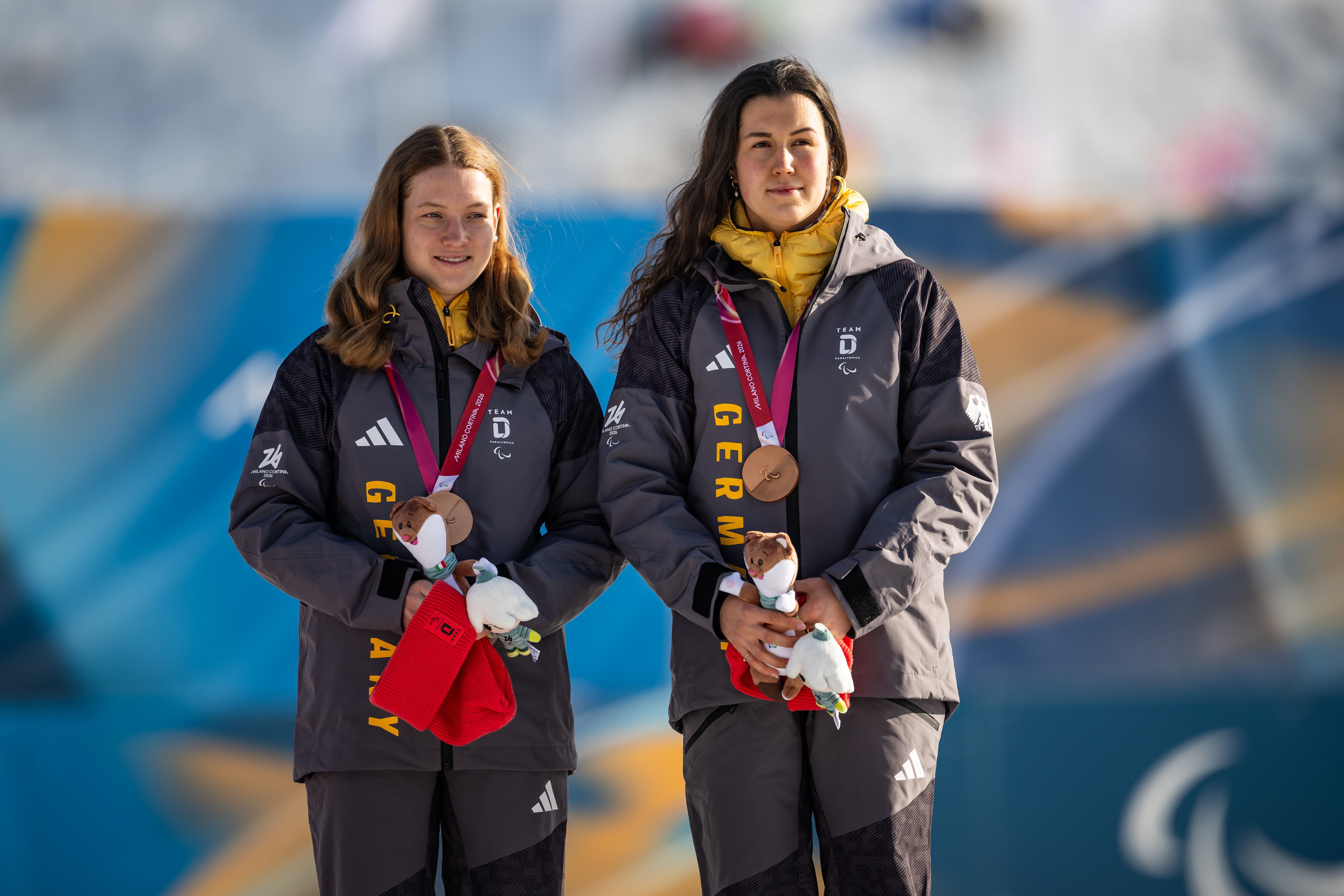 Johanna Recktenwald und Emily Weiss bei der Siegerehrung im Biathlon Einzel der Paralympics 2026, Foto: Daniel Kopatsch / VOIGT / DBS