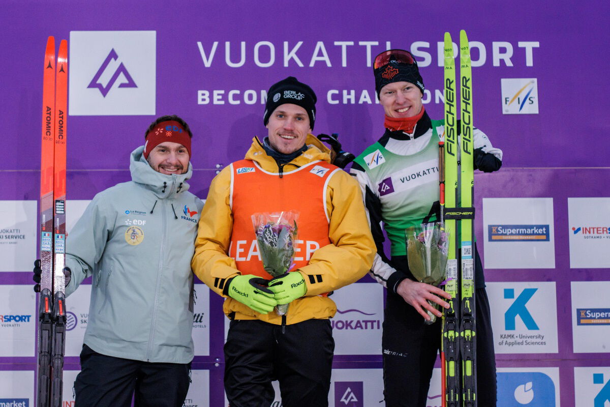 Sebastian Marburger bei der Flower Ceremony zwischen Benjamin Daviet und Mark Arendz, Foto: Vuokatti Sport.